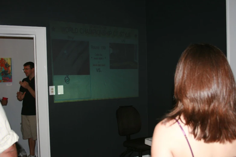 the man is making a presentation on the screen behind a woman