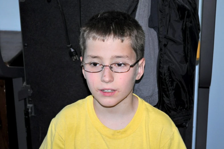 a  in glasses standing in front of an organized closet