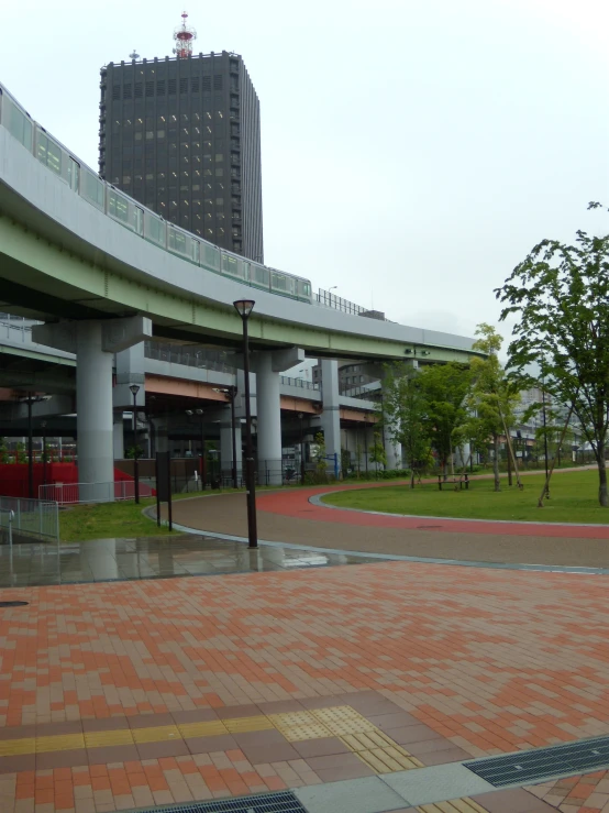 a green building sits over a sidewalk in a city