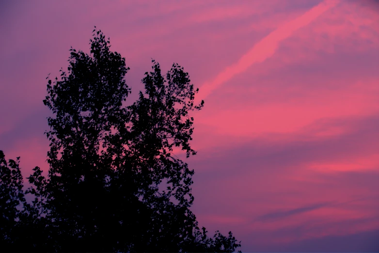 the sky is purple and pink as the sun sets in the horizon