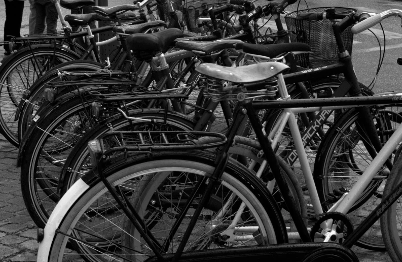 many bikes in a parking lot parked side by side