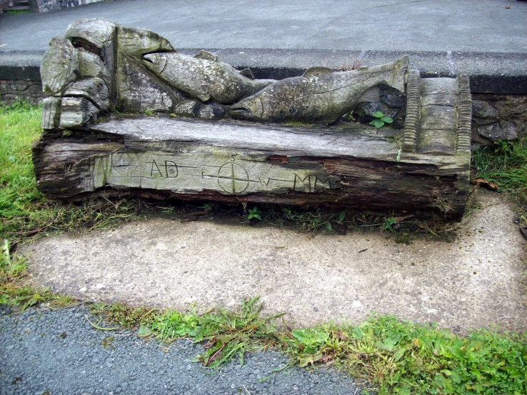 a carved out bench sitting next to an open road