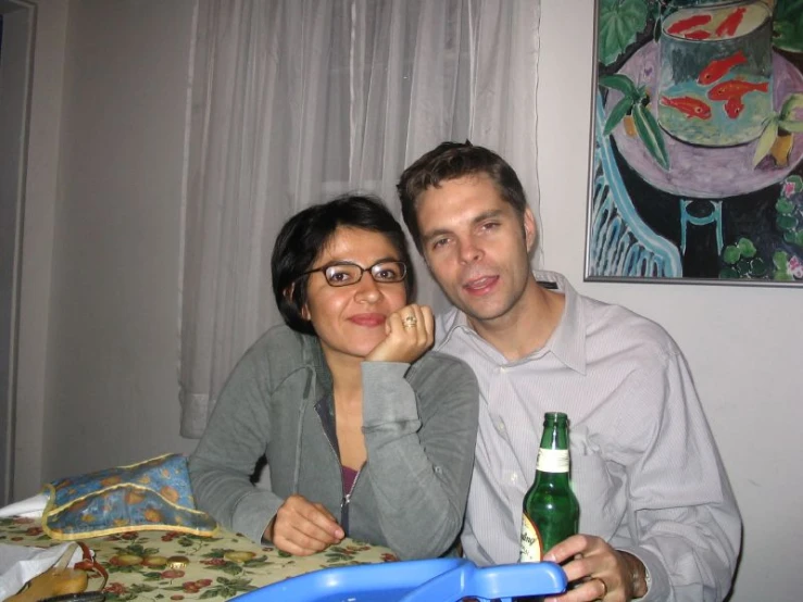 a man and a woman sitting next to each other in front of a table