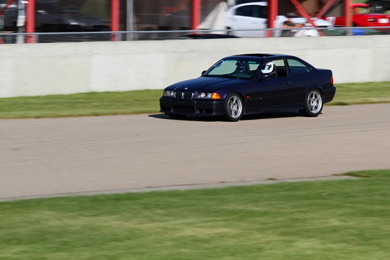 a black car in front of a gray wall