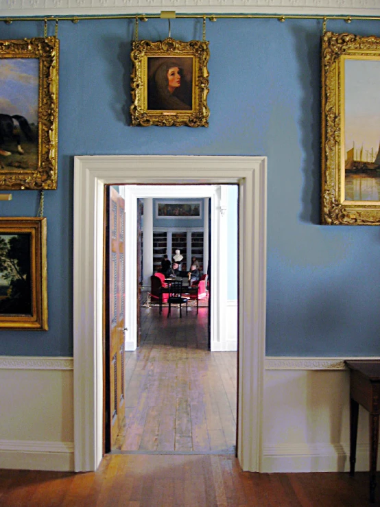 an open door leading to a dining room with pictures