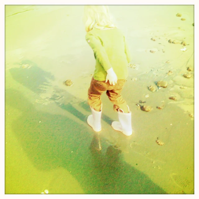 a  walking in shallow water on a beach