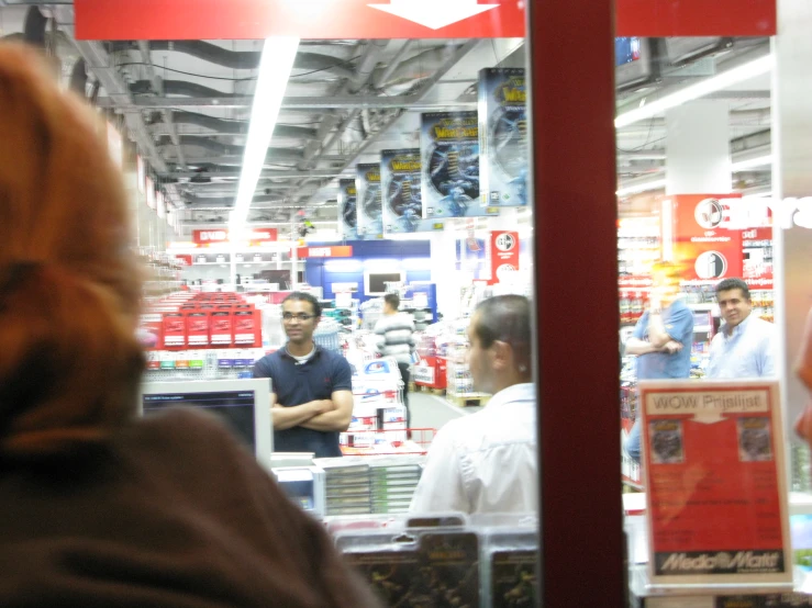 a store with many customers and a man in the window talking