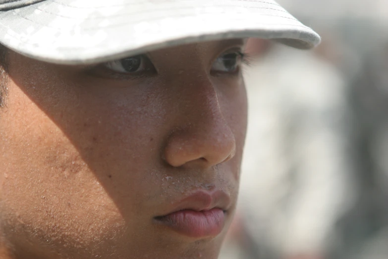 a man's frecky baseball hat with his eyes closed