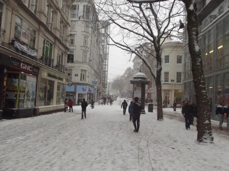 some people walking in the snow on a street