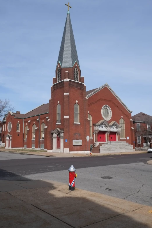 the red and white fire hydrant is in front of the old church