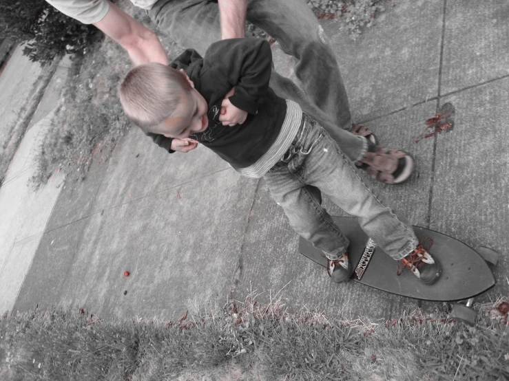 a young man on skateboard next to sidewalk