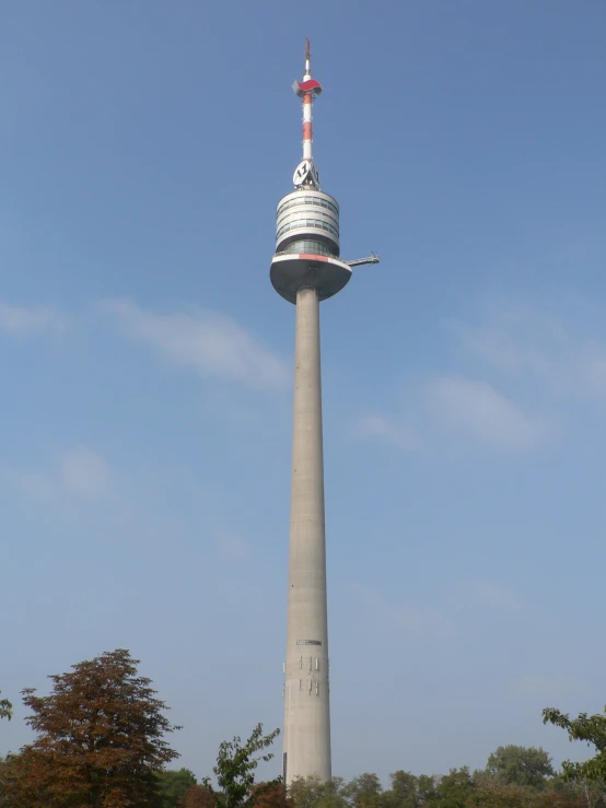 a tall building with a white tower with a red top