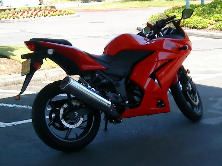 a red and black motorcycle parked in a parking lot