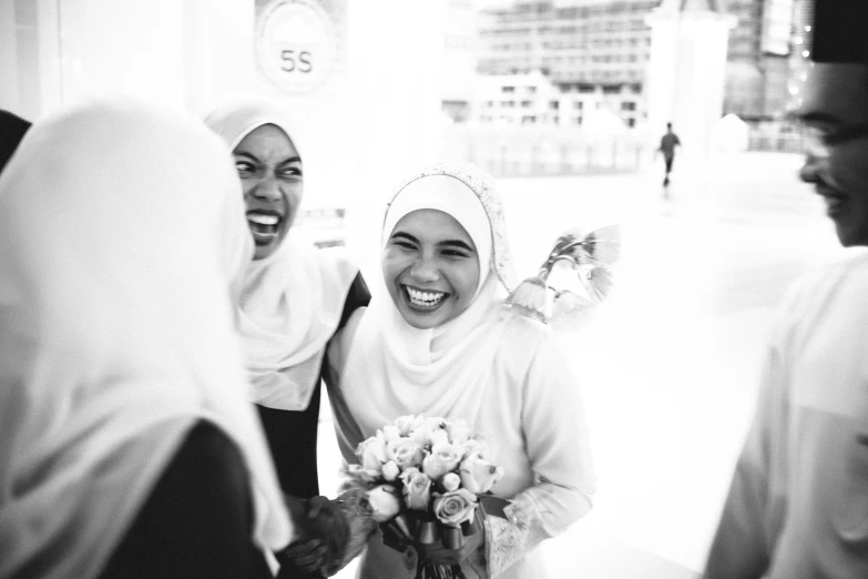 a woman smiling as she holds a bouquet of flowers