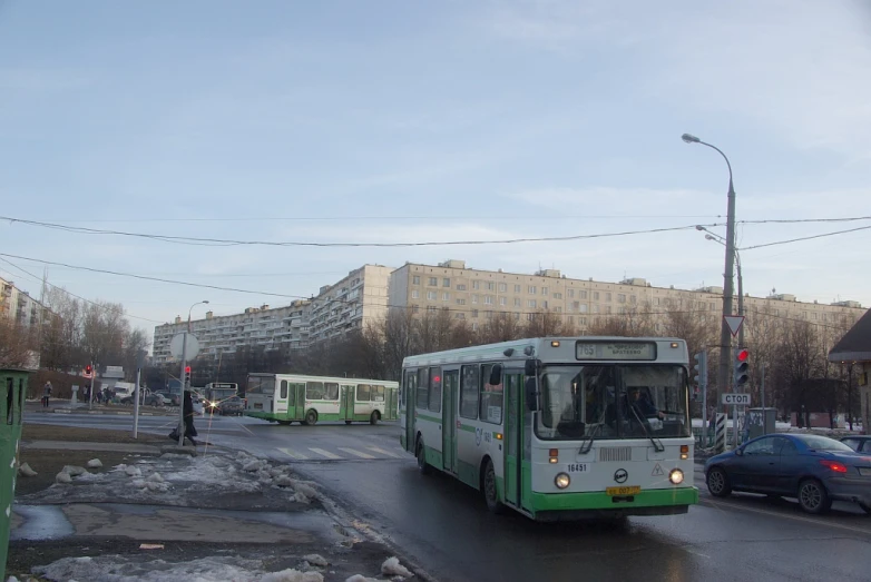 a green bus driving down a city street