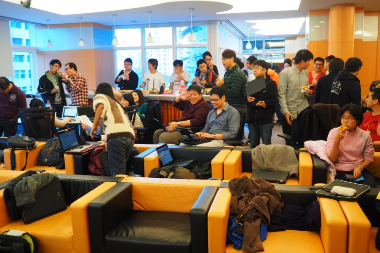 a large group of people stand in a lobby