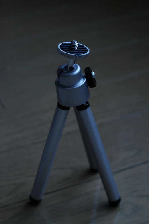 a silver tripod with an action ball and camera on top
