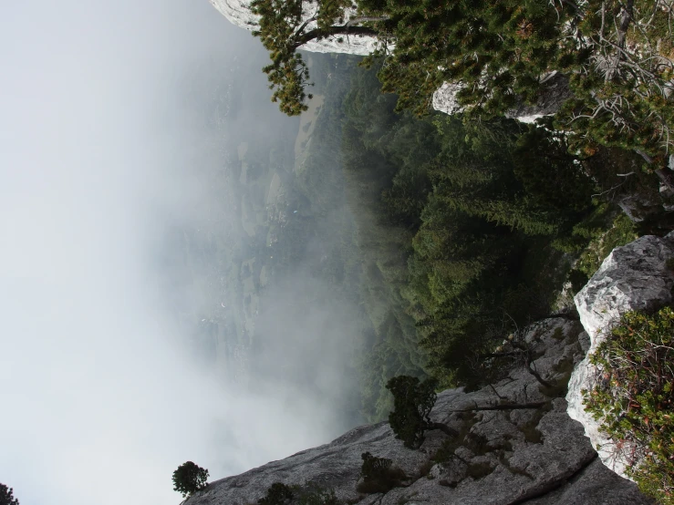 mountain with mist and fog rolling over and valley below