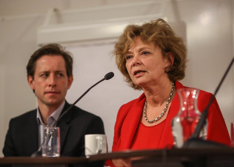 a couple of people sitting at a table with a microphone