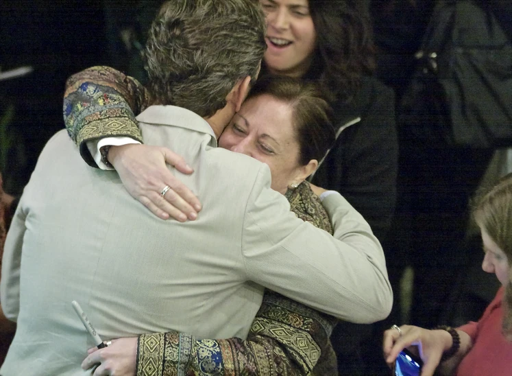 people hugging on the steps of an entrance