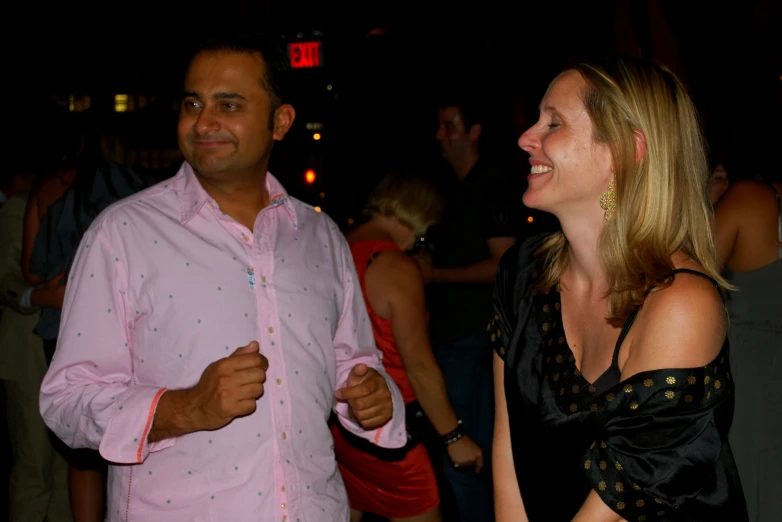 people stand at a party with pink and black clothes