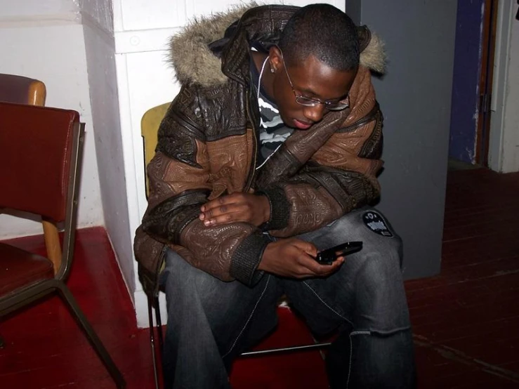 a man sitting down while using his cellphone