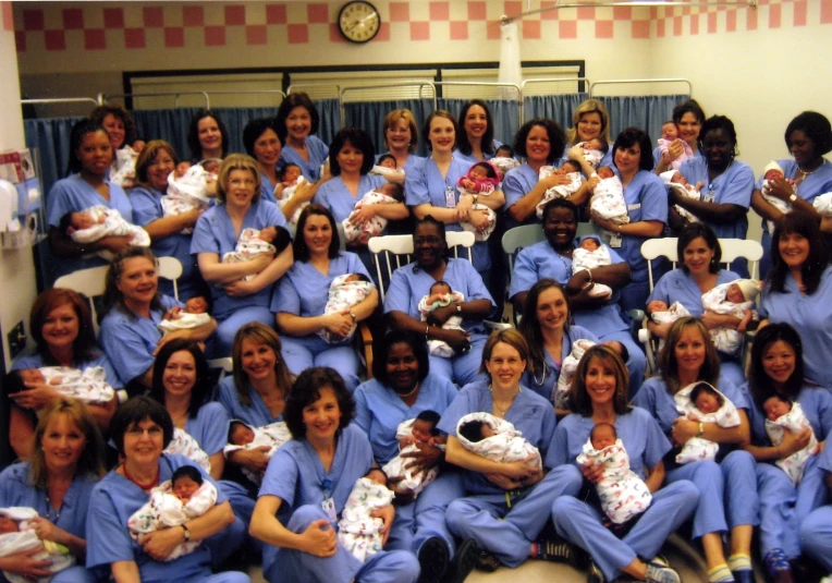 a bunch of woman holding babies posing for a po