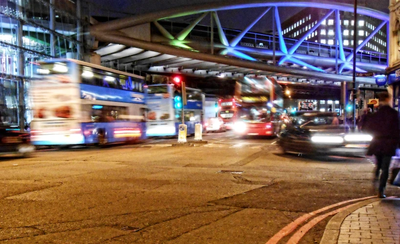 a large city street at night with cars and buses