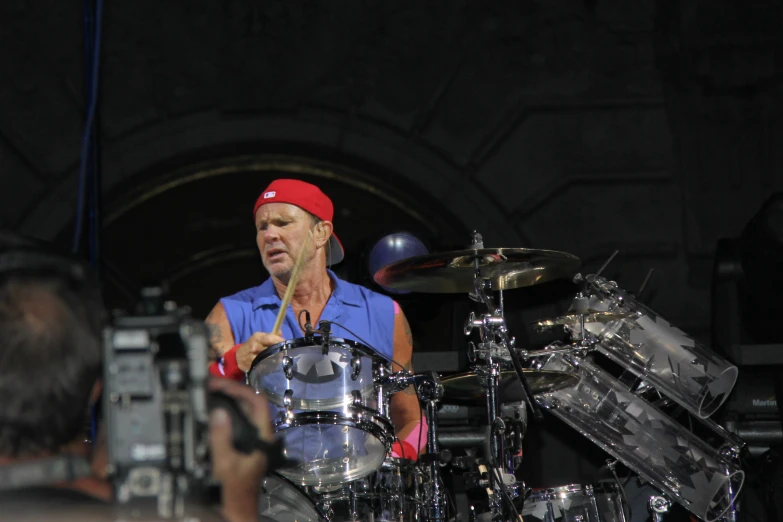 a man with a red cap is playing drums