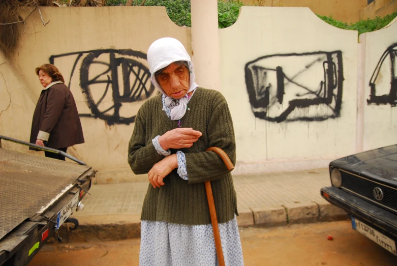 a woman in a green sweater and bonnet is standing