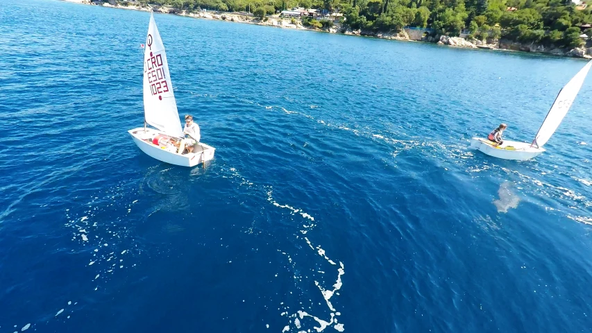 two sailboats in the middle of blue water