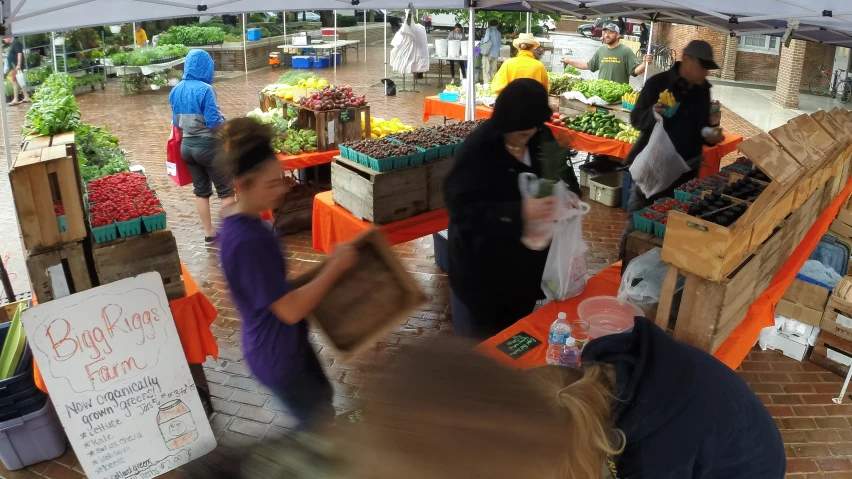 some people standing around with boxes of vegetables