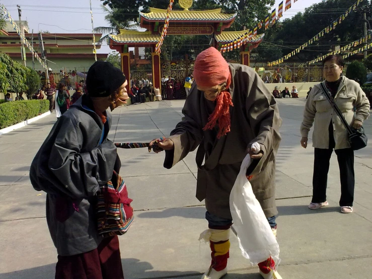 a man standing next to another man wearing a white bag