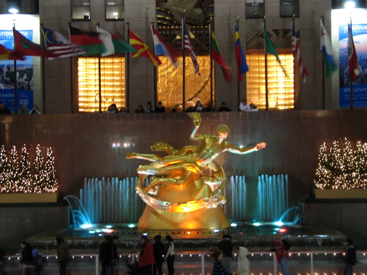 a crowd watches in line as large statue lights up at night