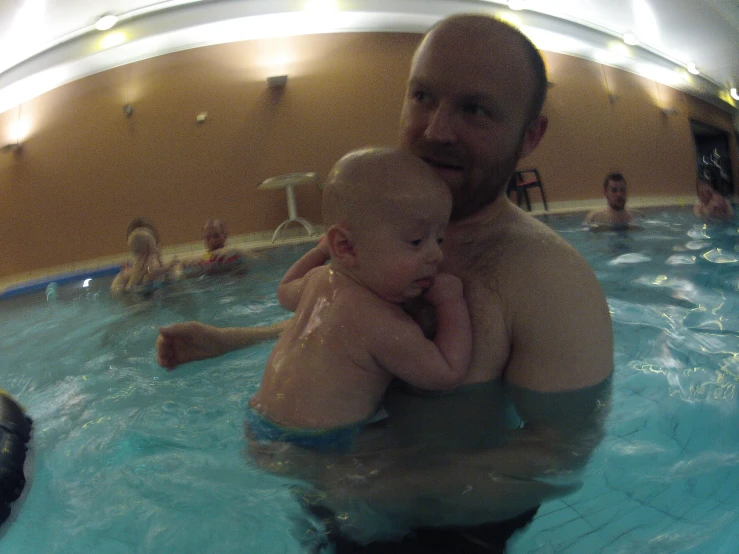 two people in the pool with a baby