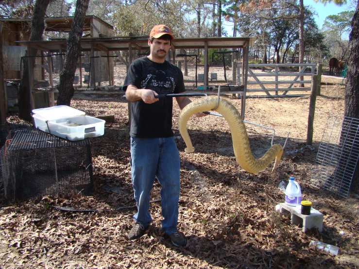 a man standing next to another man who is holding a snake