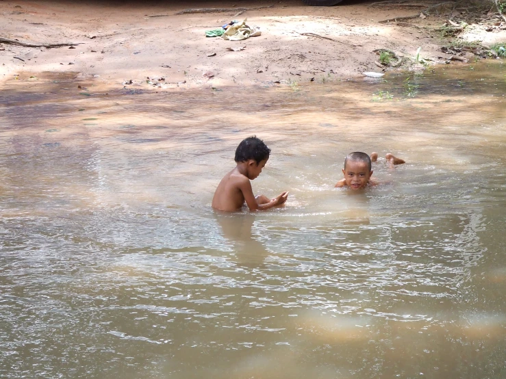 two children swimming in a body of water