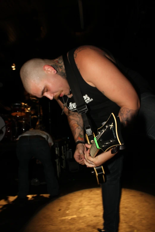 a man with piercings on holding his guitar