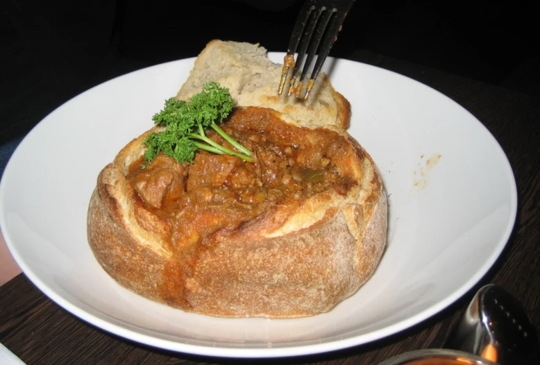 a plate with bread, meat and a side item