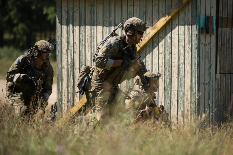 the soldiers are walking in the grass beside the building