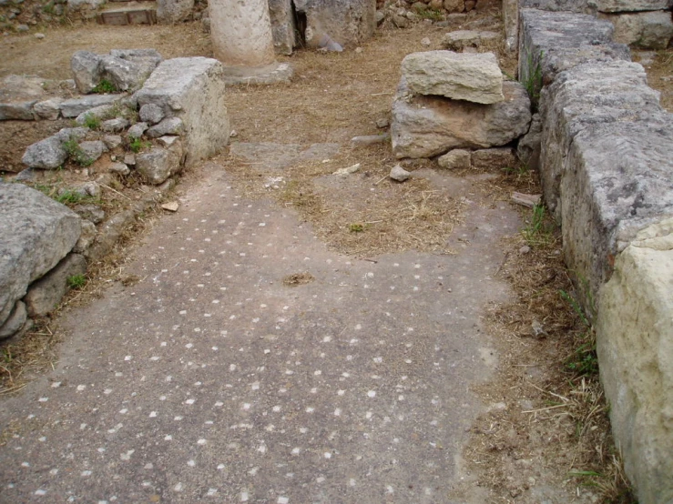 a dirt and stone walkway next to a pile of large rocks