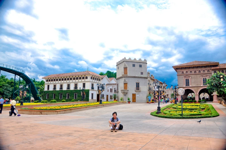 people sit in a park and walk near large buildings