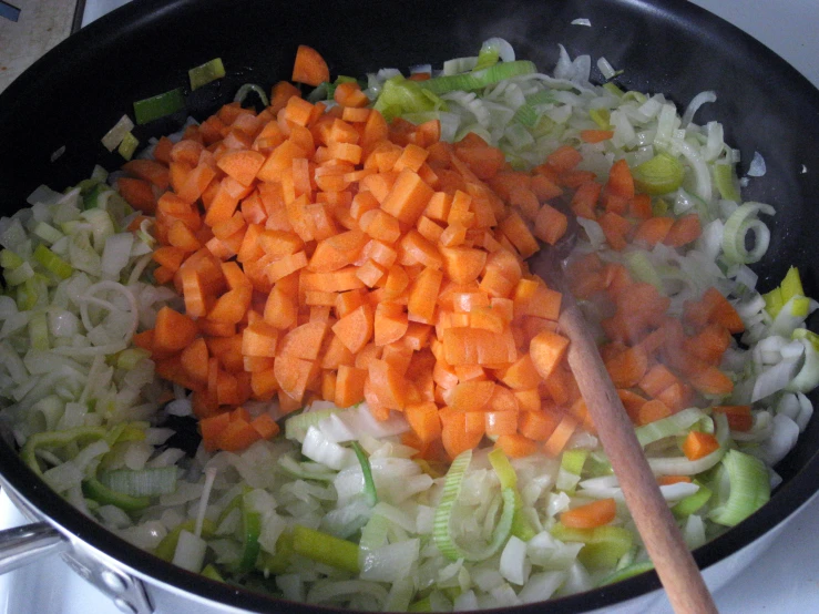 chopped vegetables are being cooked in a set