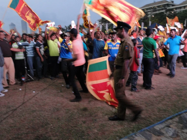 people stand around holding flags and shield during an event