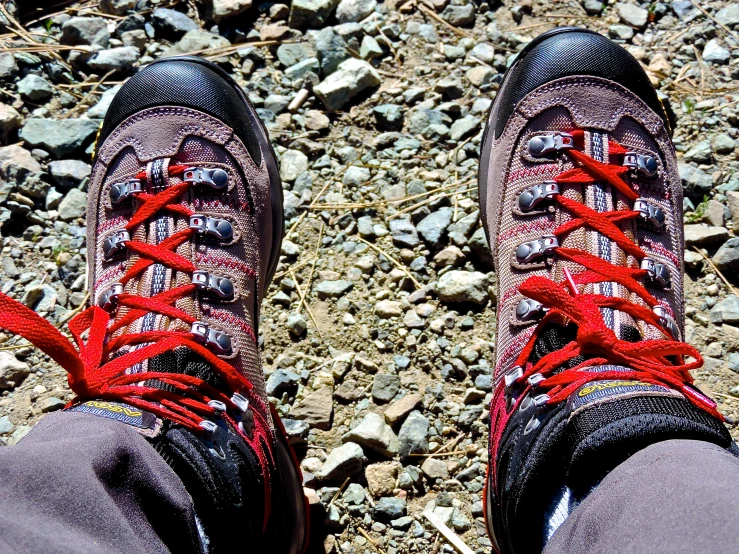 a pair of hiking boots sitting on top of a rocky ground