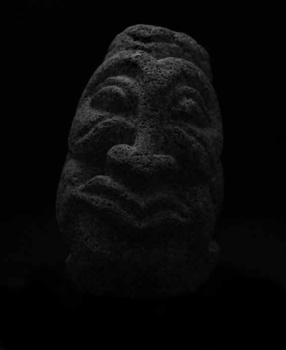 a stone sculpture with a face that is carved into it