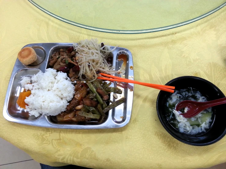 the table has two plates and a tray of food on it