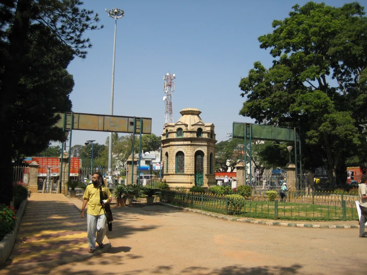 two people walk towards a statue in a city park