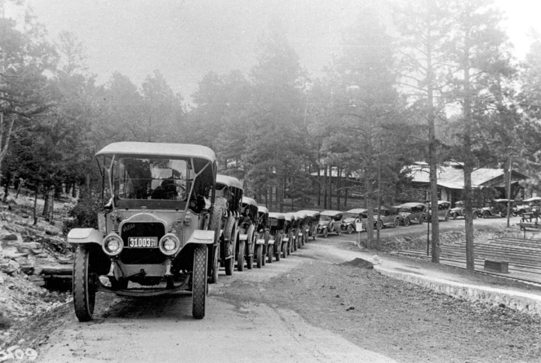 black and white pograph of people lined up in jeeps