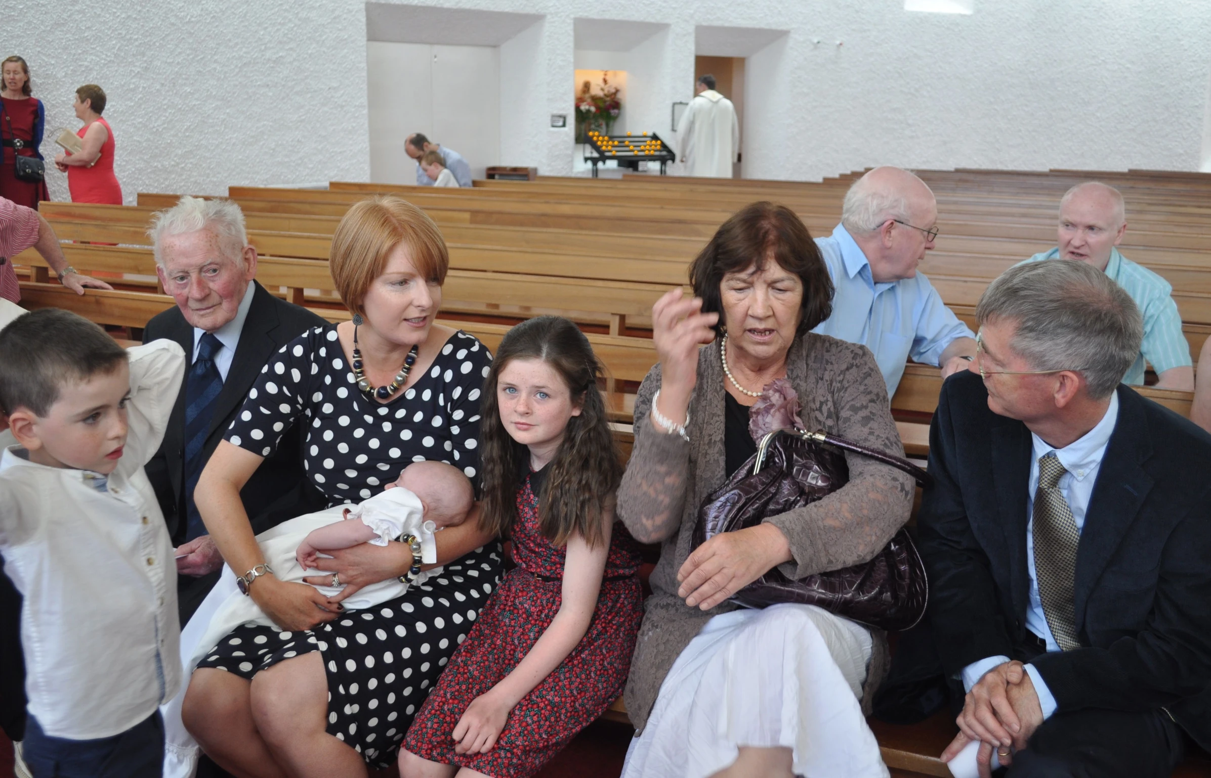 several people sitting together, with one holding a baby